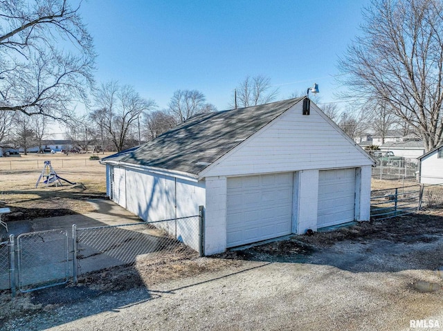 detached garage featuring a gate and fence