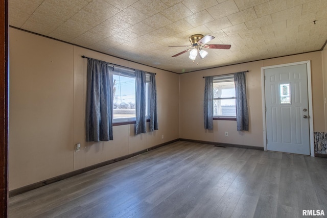 entrance foyer featuring a ceiling fan, visible vents, baseboards, and wood finished floors