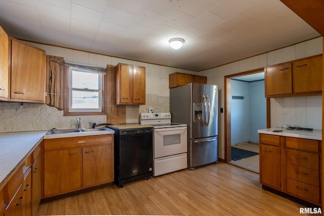 kitchen with black dishwasher, light countertops, electric range, a sink, and stainless steel fridge with ice dispenser