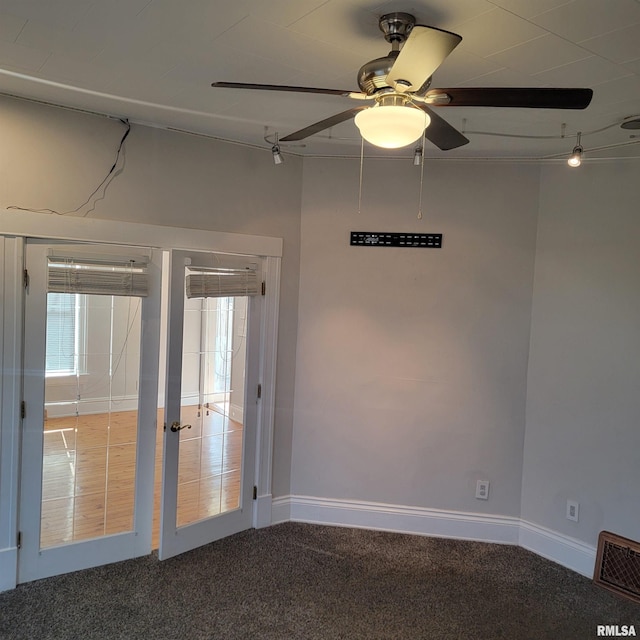 empty room featuring carpet floors, french doors, visible vents, a ceiling fan, and baseboards