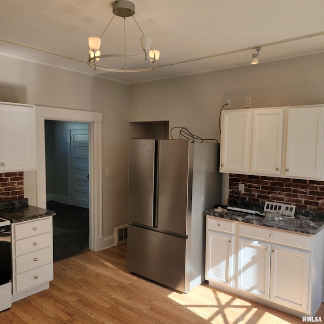 kitchen with light wood finished floors, visible vents, white cabinetry, and stainless steel appliances