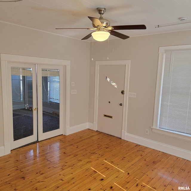 entrance foyer with ceiling fan, french doors, light wood-style flooring, and baseboards