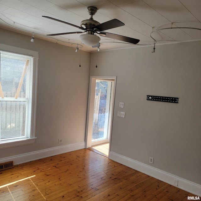 spare room with a healthy amount of sunlight, light wood-style floors, and baseboards