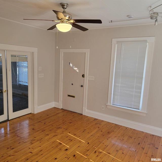 interior space featuring ceiling fan, hardwood / wood-style flooring, and baseboards