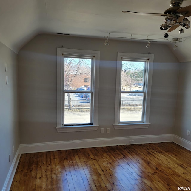 bonus room with dark wood-style floors, a wealth of natural light, vaulted ceiling, and visible vents