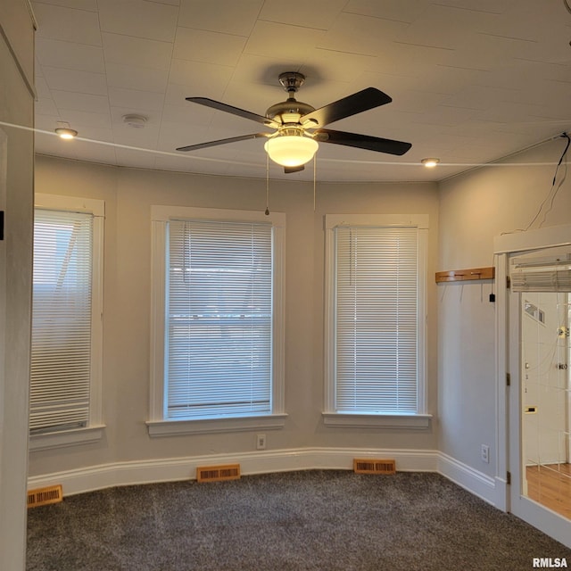 unfurnished room with carpet floors, visible vents, and baseboards