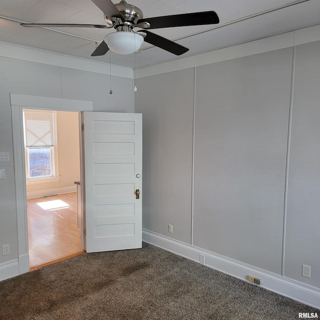 spare room featuring a ceiling fan and carpet flooring