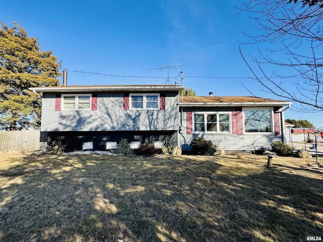 tri-level home featuring a front yard and fence