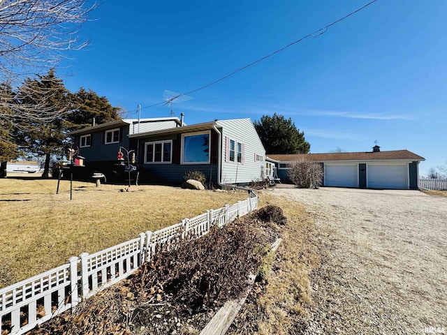 view of front of property featuring a garage, a front lawn, and fence