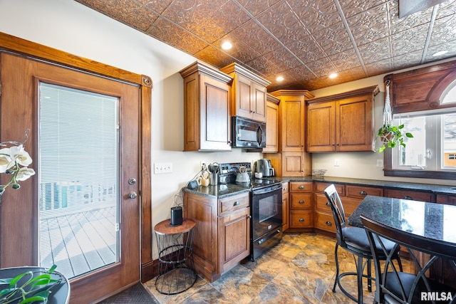 kitchen with an ornate ceiling, brown cabinets, recessed lighting, dark stone counters, and black appliances