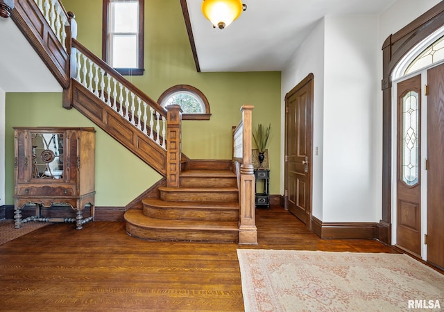 foyer entrance with baseboards, stairway, and wood finished floors