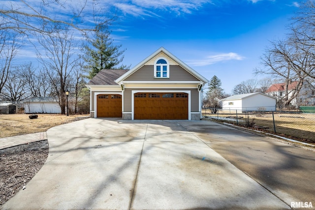 view of front of property with concrete driveway, fence, a garage, stone siding, and an outdoor structure