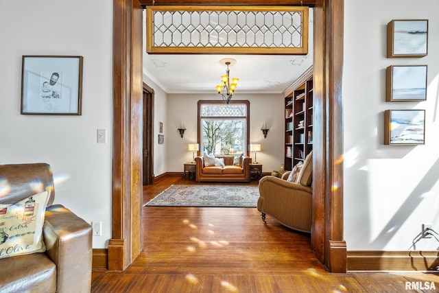 interior space featuring baseboards, wood finished floors, and crown molding