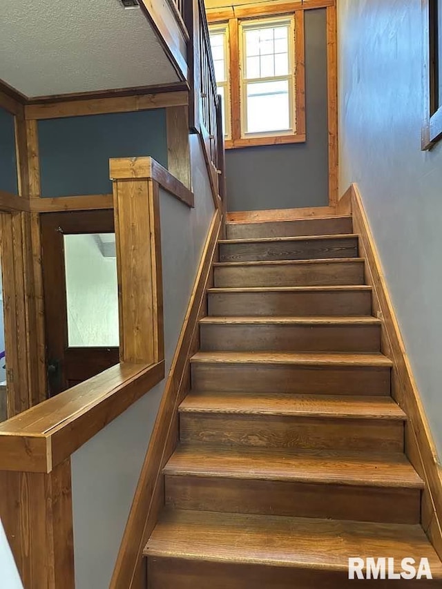 stairway with a textured ceiling