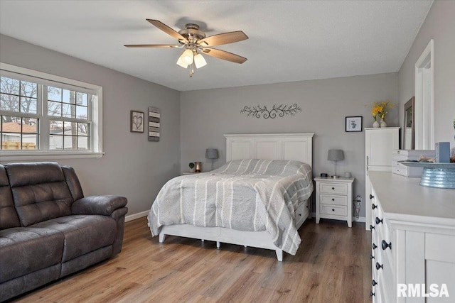 bedroom with ceiling fan, baseboards, and wood finished floors