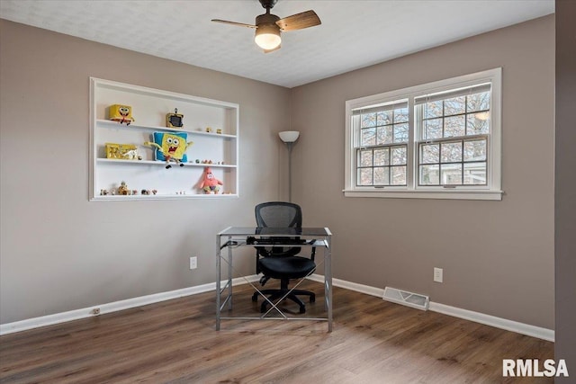 office area with visible vents, baseboards, a ceiling fan, and wood finished floors