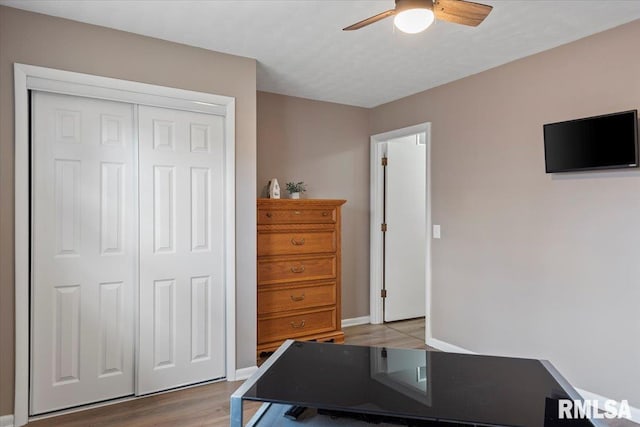 office with baseboards, wood finished floors, and a ceiling fan