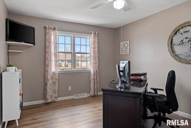 office featuring wood finished floors, baseboards, visible vents, ceiling fan, and a textured ceiling