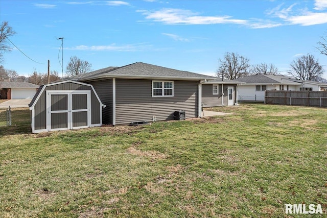 back of house featuring an outdoor structure, a yard, a fenced backyard, and a shed