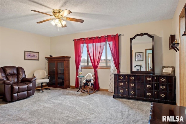 sitting room featuring a textured ceiling, ceiling fan, carpet, and baseboards