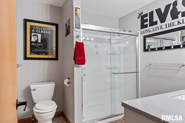 bathroom with a textured ceiling, a stall shower, and toilet