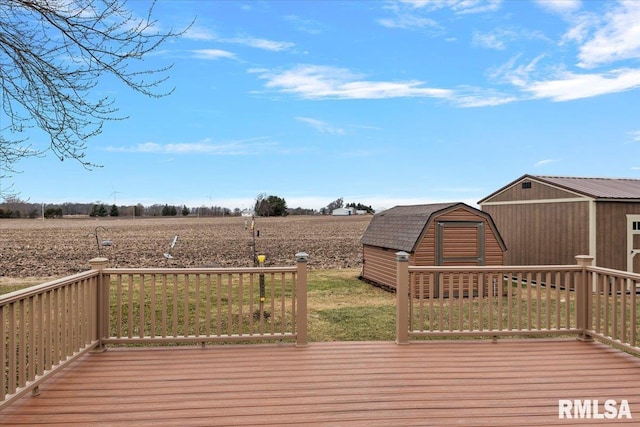 wooden terrace with a rural view, an outdoor structure, and a storage unit