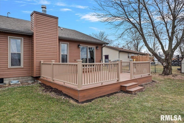 back of property with a deck, a yard, a chimney, and fence