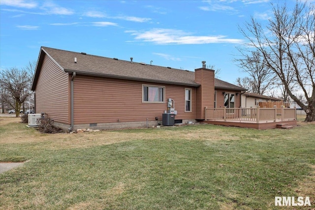 rear view of property featuring a lawn, a chimney, roof with shingles, a wooden deck, and central AC