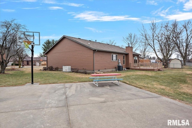 rear view of property featuring a lawn, an outbuilding, crawl space, a wooden deck, and a patio area