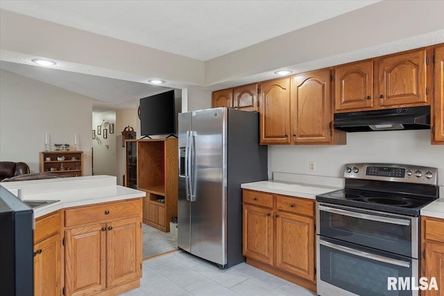 kitchen with light countertops, appliances with stainless steel finishes, brown cabinets, and under cabinet range hood