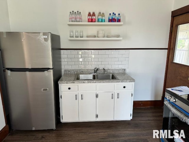 kitchen with dark wood finished floors, white cabinetry, stainless steel appliances, and a sink