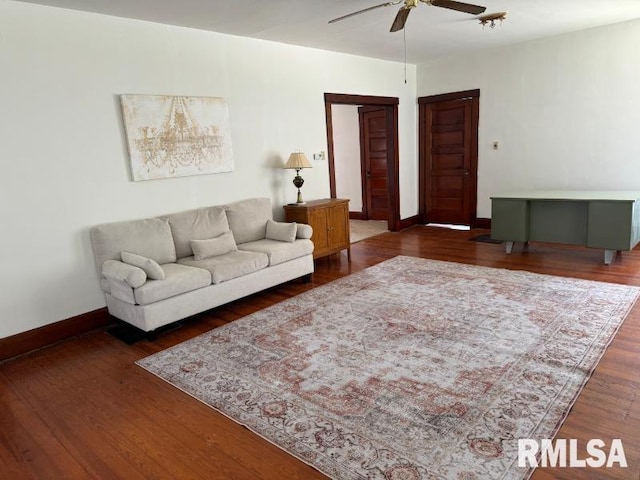 living area with a ceiling fan, baseboards, and wood finished floors