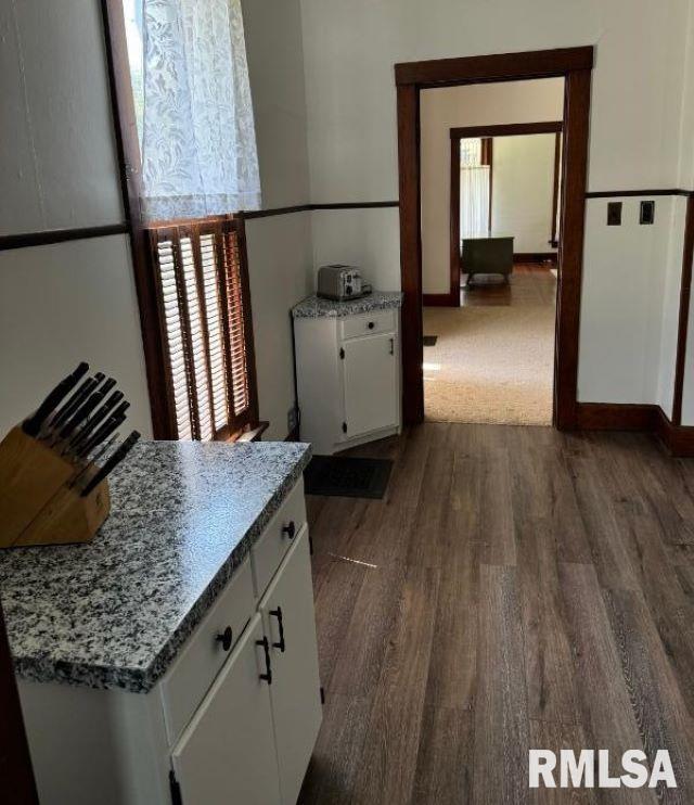 kitchen featuring dark wood-style floors, baseboards, and white cabinets