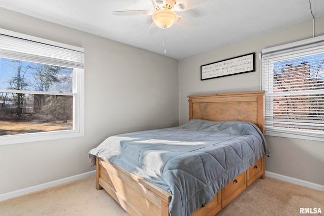 bedroom with light carpet, ceiling fan, and baseboards