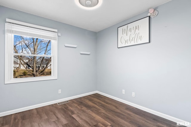 unfurnished room featuring dark wood-style floors, visible vents, and baseboards