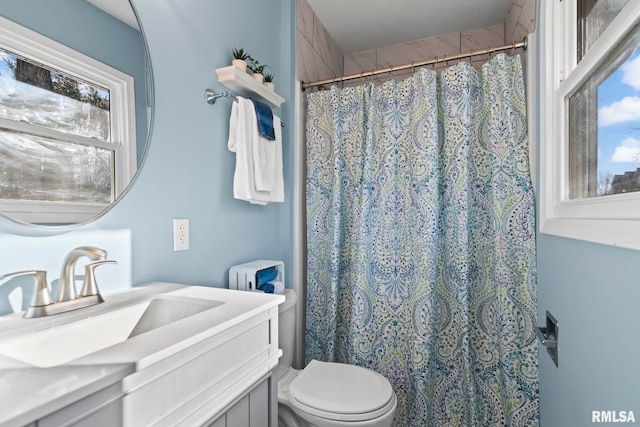 bathroom featuring toilet, vanity, and a shower with curtain