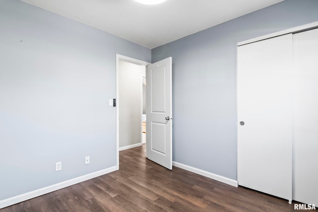 unfurnished bedroom with a closet, baseboards, and wood finished floors