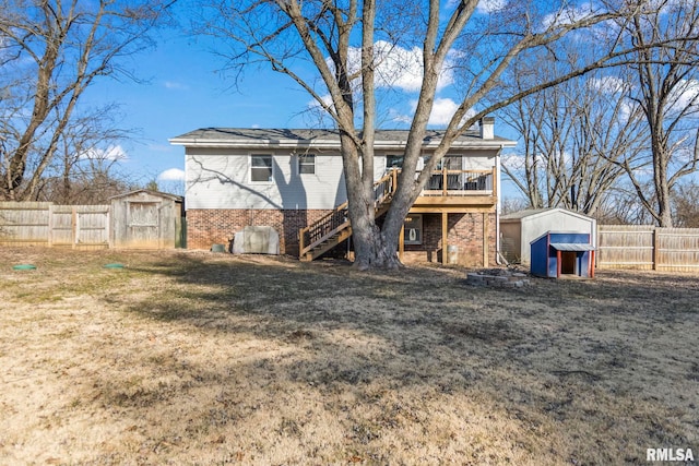 back of house featuring a storage unit, an outbuilding, and brick siding