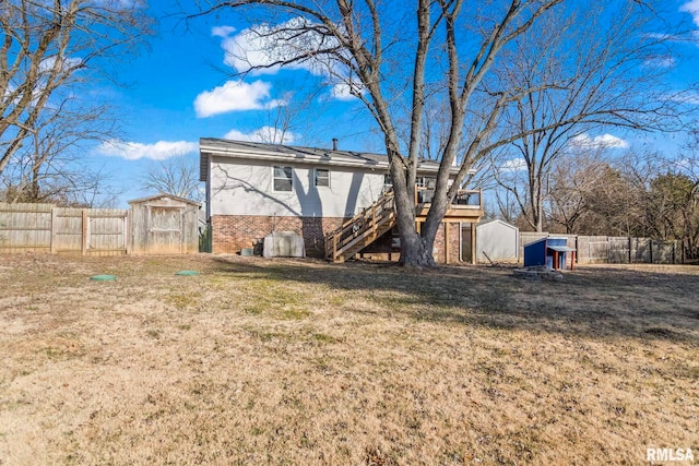 rear view of house featuring a storage shed, a fenced backyard, brick siding, and an outdoor structure