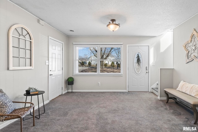 entrance foyer with baseboards, carpet floors, a textured ceiling, and stairs