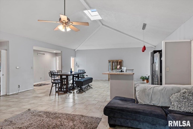 dining area featuring a skylight, visible vents, light tile patterned flooring, ceiling fan, and baseboards