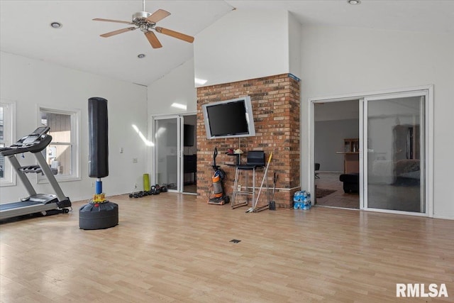 exercise room with high vaulted ceiling, wood finished floors, and a ceiling fan