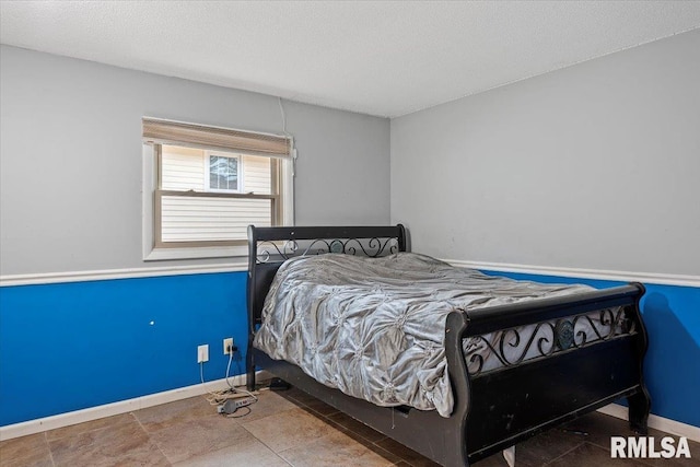 bedroom featuring baseboards and a textured ceiling