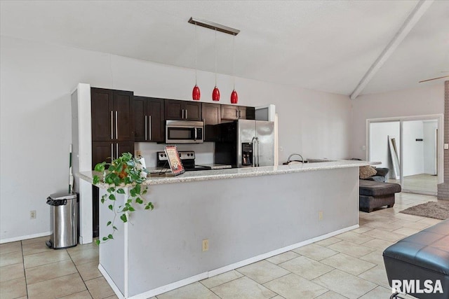 kitchen featuring light tile patterned floors, vaulted ceiling, light countertops, appliances with stainless steel finishes, and dark brown cabinets