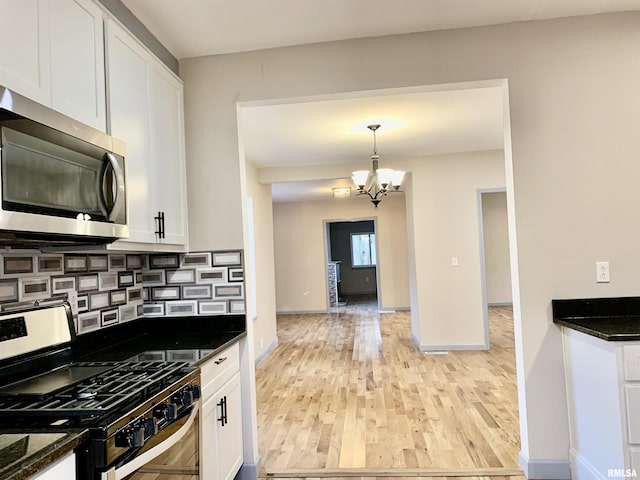 kitchen with stainless steel appliances, backsplash, and white cabinets