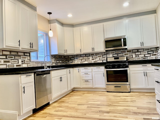 kitchen with white cabinets, light wood-style floors, and stainless steel appliances