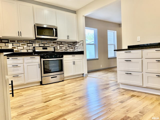 kitchen with white cabinets, tasteful backsplash, stainless steel appliances, and light wood-style flooring