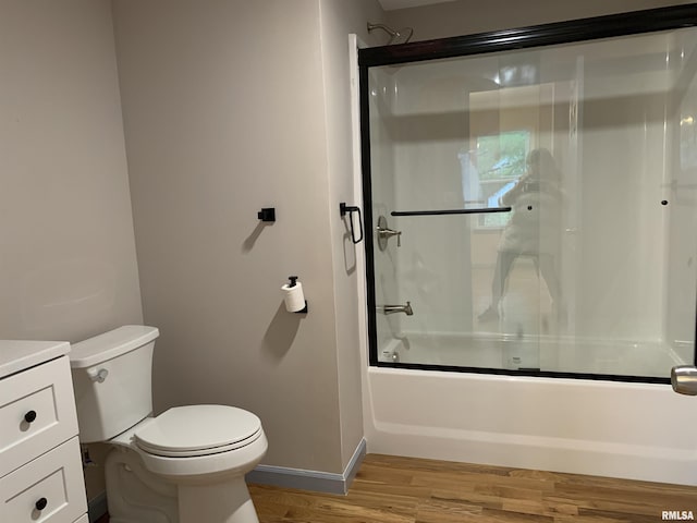 full bathroom featuring toilet, enclosed tub / shower combo, vanity, wood finished floors, and baseboards