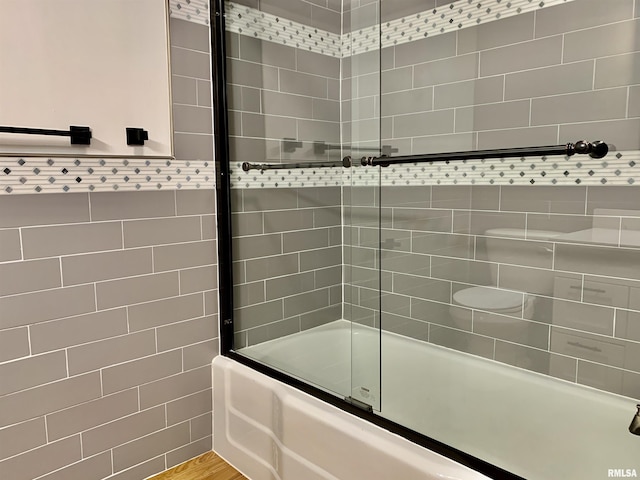 bathroom featuring combined bath / shower with glass door