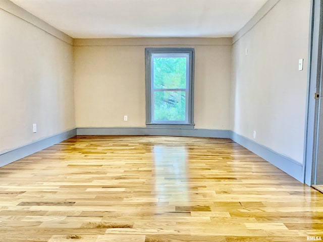 empty room with light wood finished floors and baseboards